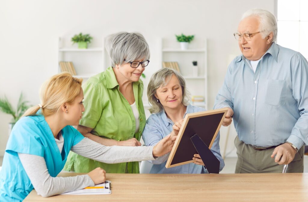 Seniors engaging in a group activity with a caregiver in a bright room showcasing community involvement in assisted living.