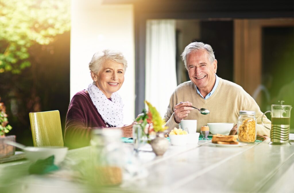 A pair of seniors happily enjoying a meal together, sharing conversation and companionship.