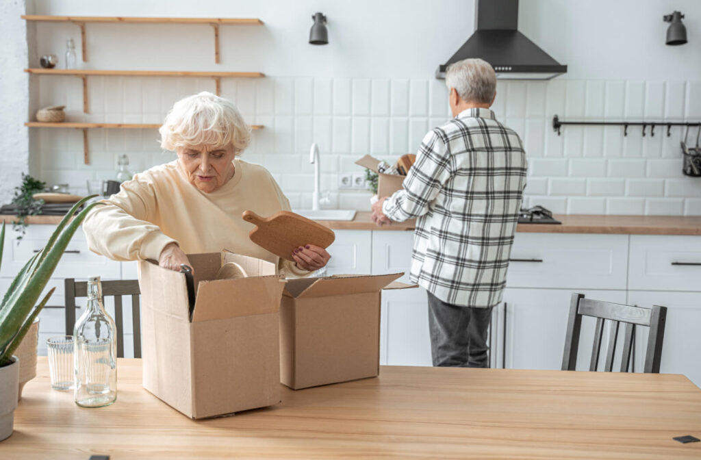 An older couple working together to pack up their kitchen for a move to assisted living.